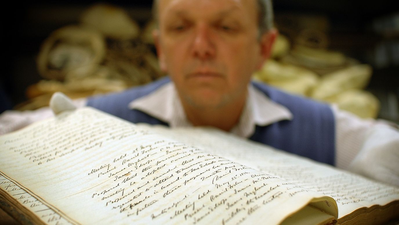 Researcher showing old records in book