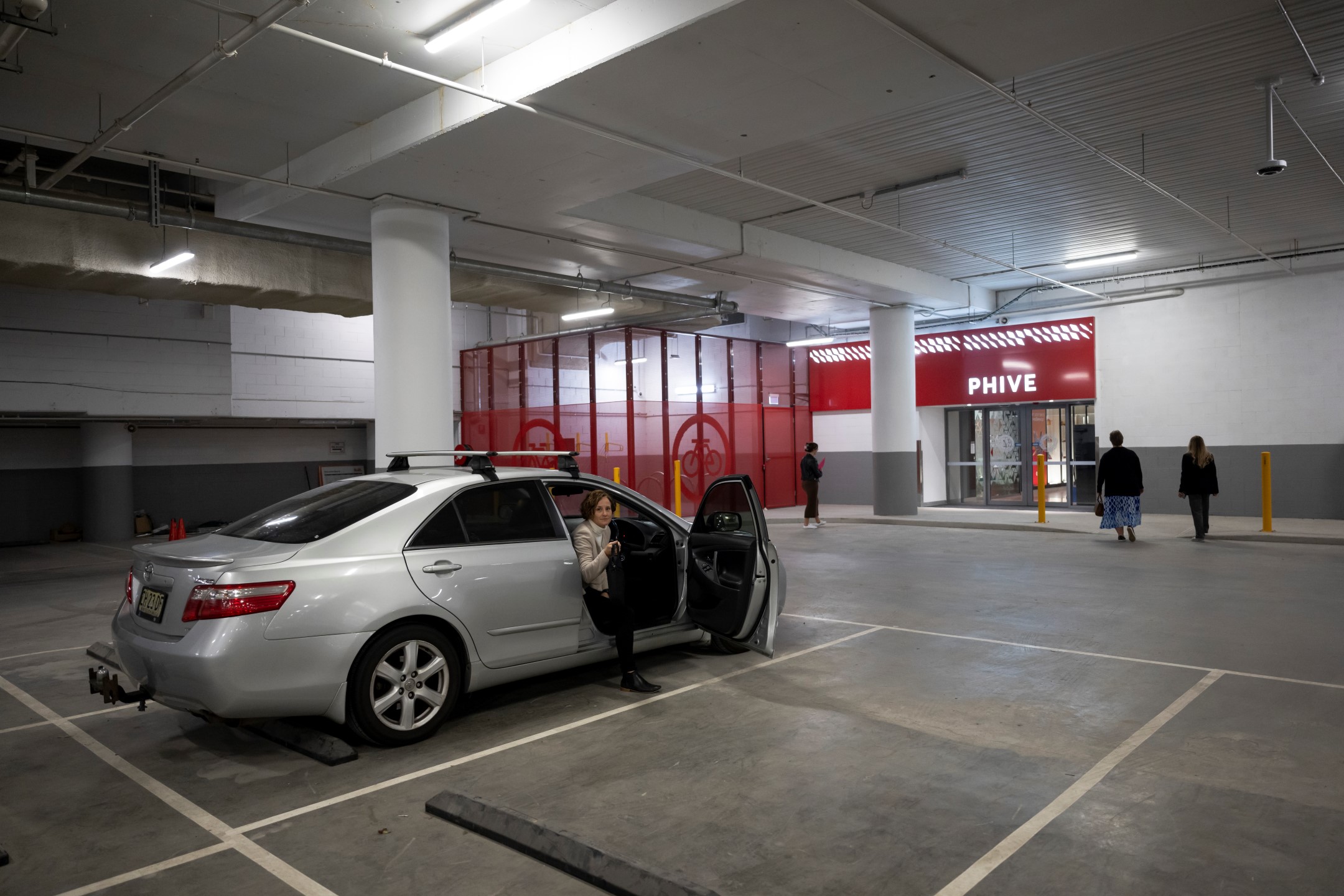 Car in car park with woman getting out