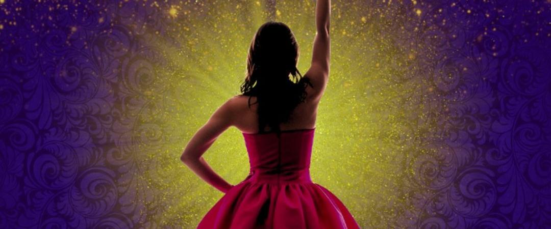 A woman in a red dress stands confidently with her back to the viewer, holding a sparkling microphone against a radiant purple and gold background.